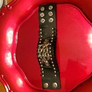 Black cuff bracelet with silver studs accents.